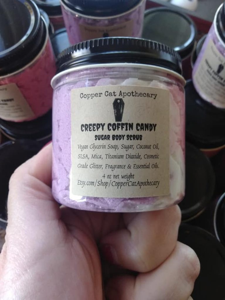 Copper Cat Apothecary Creepy Coffin Candy sugar scrub held in a woman's hand.