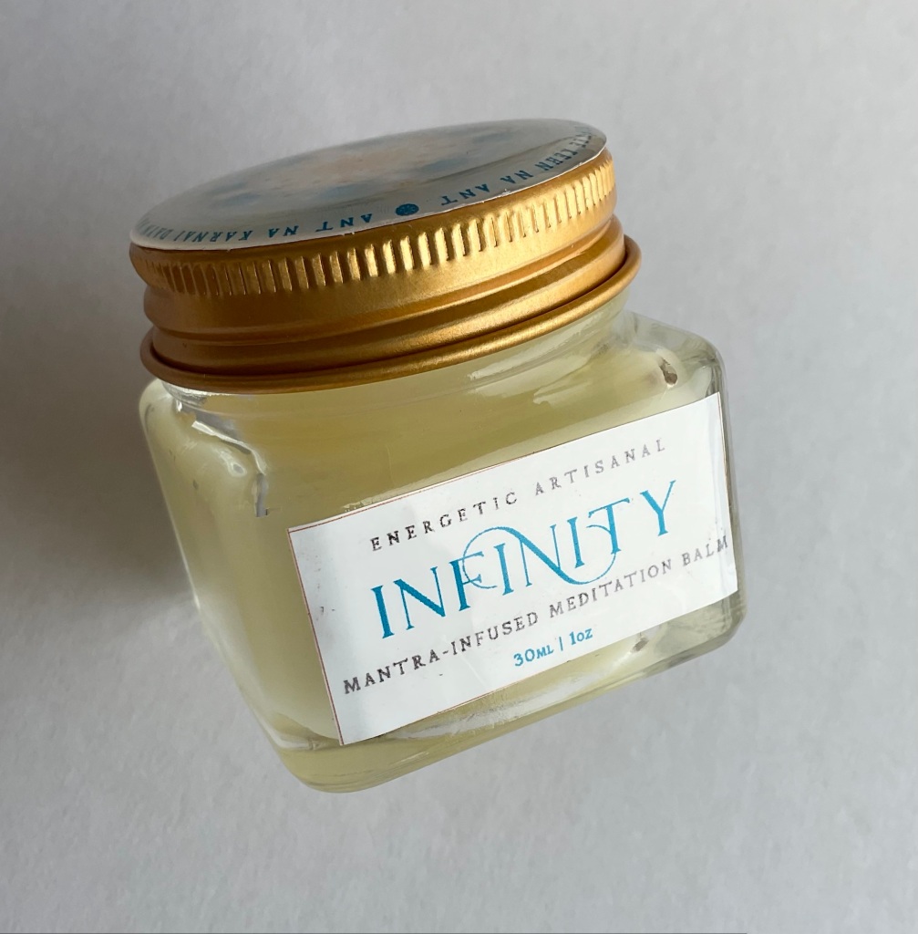 A close-up of the Infinity Meditation Perfume Balm in gentle sunlight